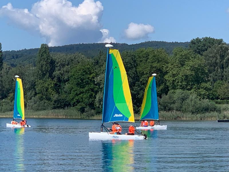 Mehrere Kindern segeln mit Booten bei einem Sommercamp in Baden Württemberg