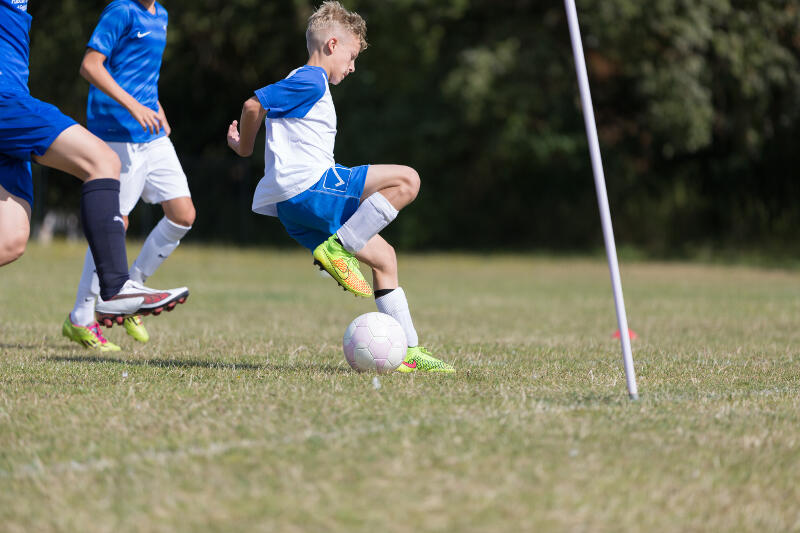 Im Fußballcamp für Kinder spielt ein Junge Fußball