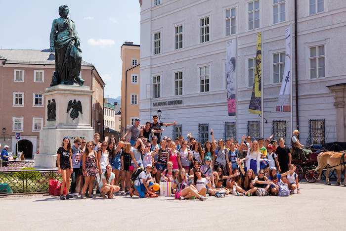 Eine große Gruppe aus dem Kinder Ferienprogramm macht ein Gruppenfoto in Salzburg