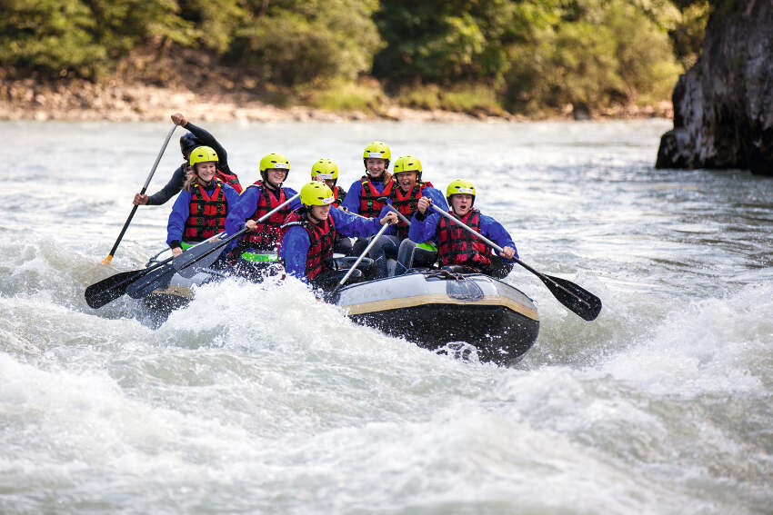 Spass mit Gummiboot auf dem Fluss im Abenteuerurlaub Kinder