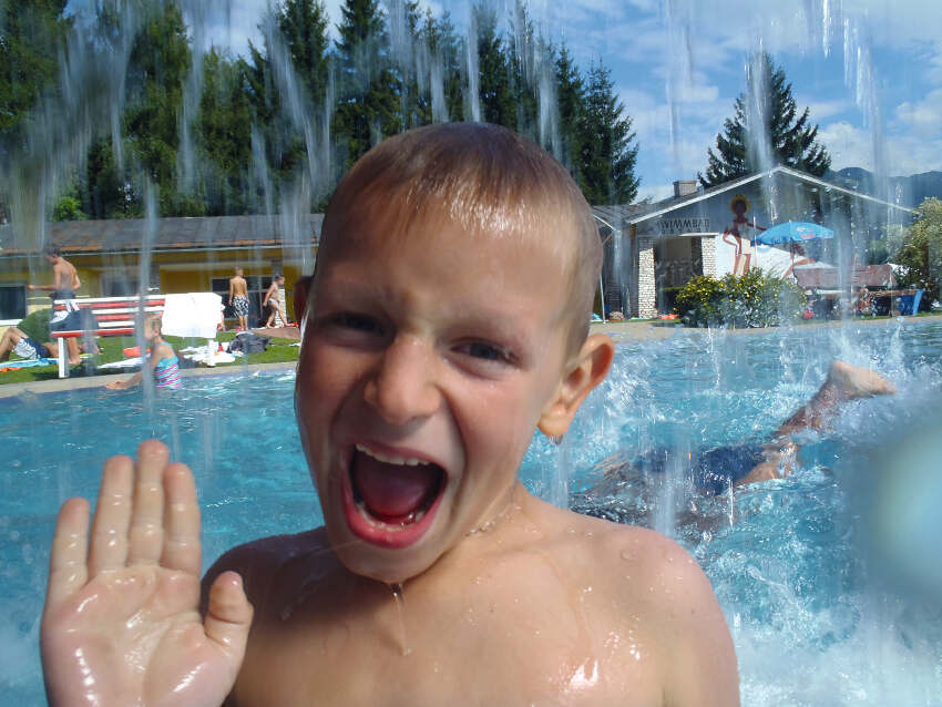 Junge unter Wasser im Freibad im Abenteuerurlaub Kinder