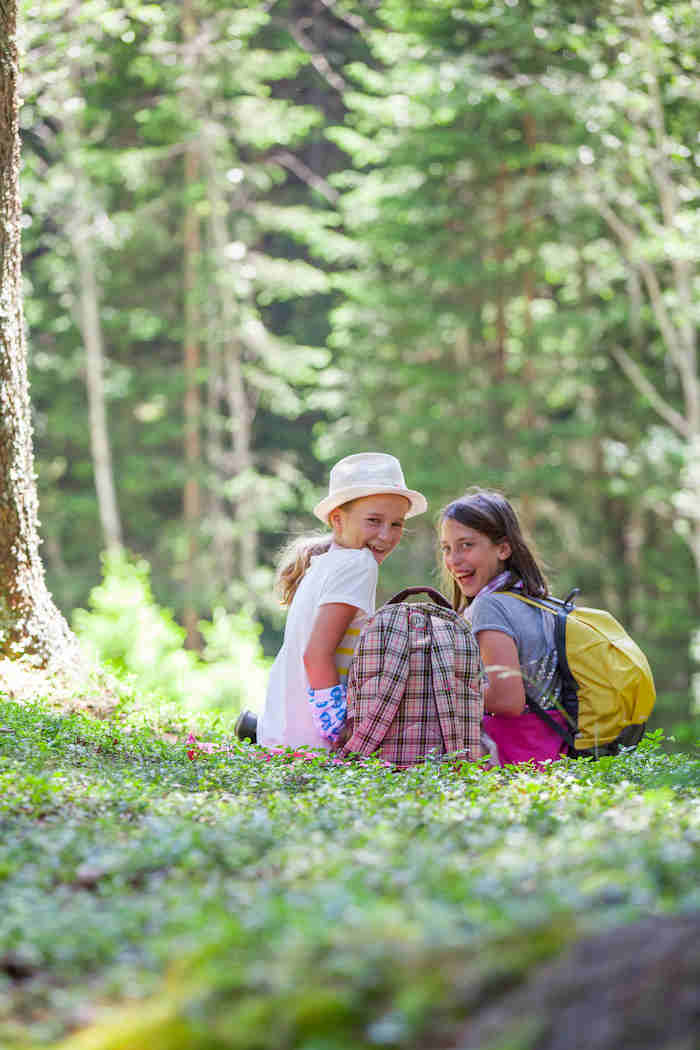Zwei Mädchen sitzen im Wald im Sommercamp Kinder