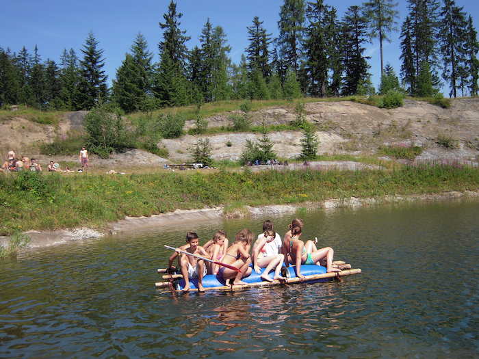 Kinder sitzen auf Floss im Sommercamp Kinder