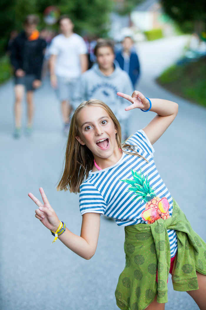 Mädchen zeigt Peace Zeichen im Sommercamp Kinder