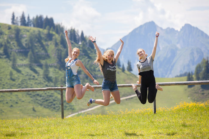 Drei Mädchen springen in die Luft im Sommercamp Kinder