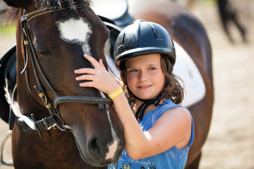 Mädchen hält Pferd im Sommercamp Kinder