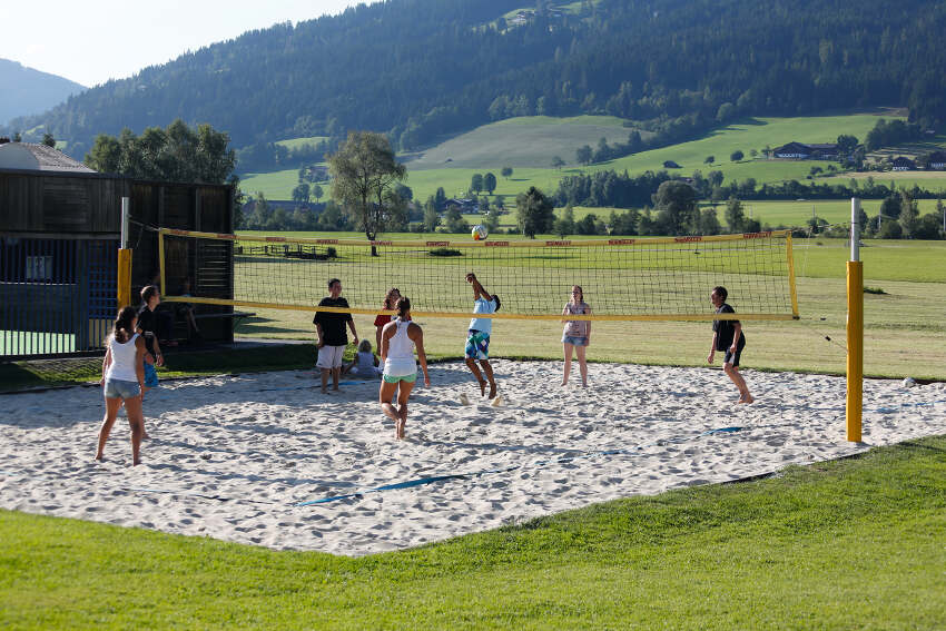 Volleyball spielen im Sandfeld im Sommercamp Kinder