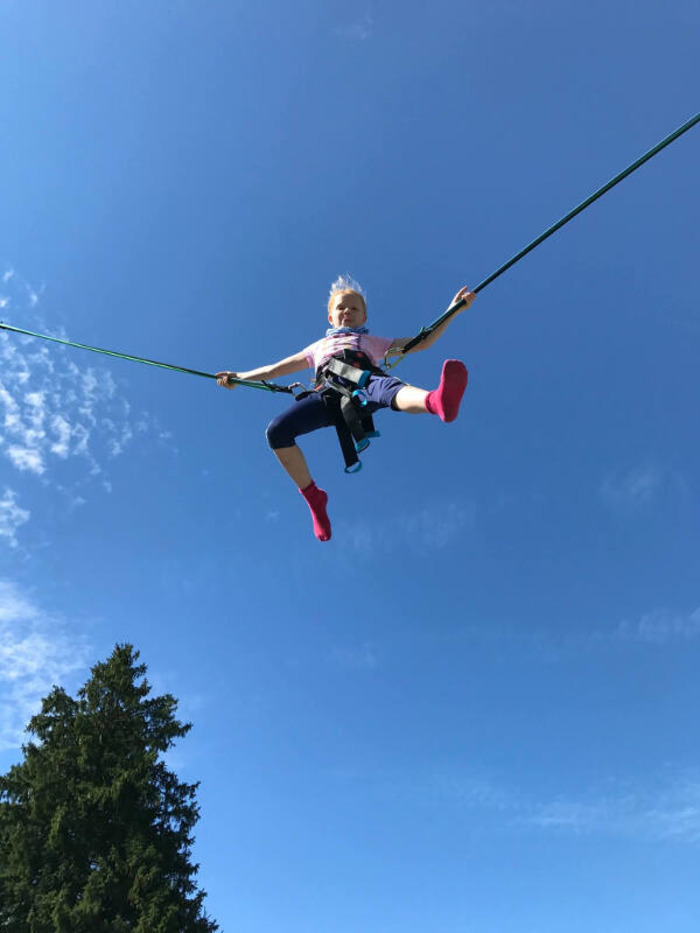 Mädchen springt in der Luft im Englisch Feriencamp