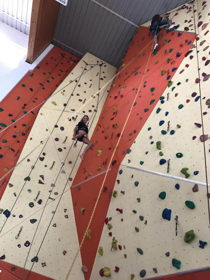 Teilnehmer klettern an Kletterwand im Englisch Feriencamp