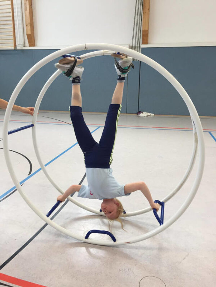 Mädchen turnt im Rhönrad im Englisch Feriencamp