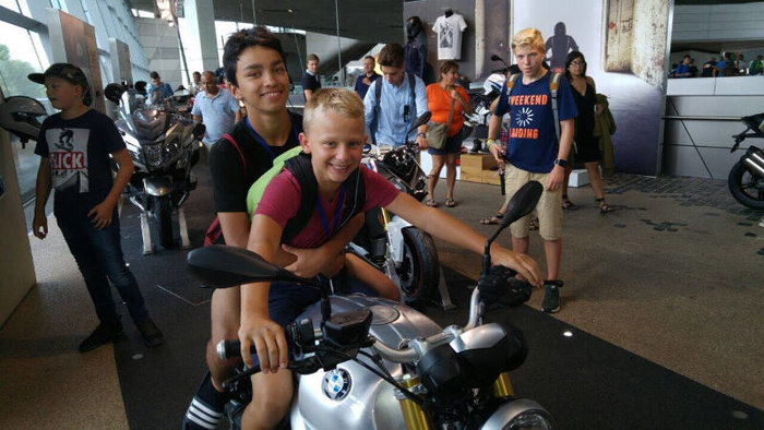 Jungs sitzen auf Motorrad im Englisch Feriencamp