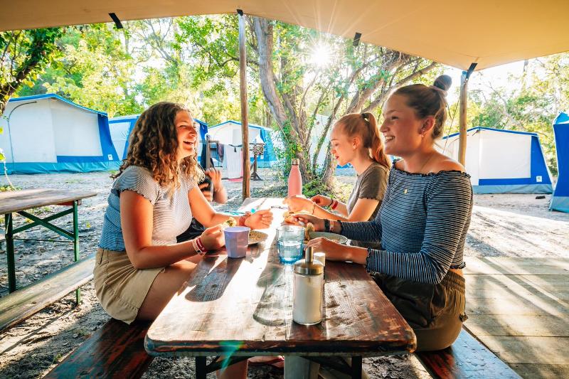 Mädchen essen gemeinsam auf der Surffreizeit