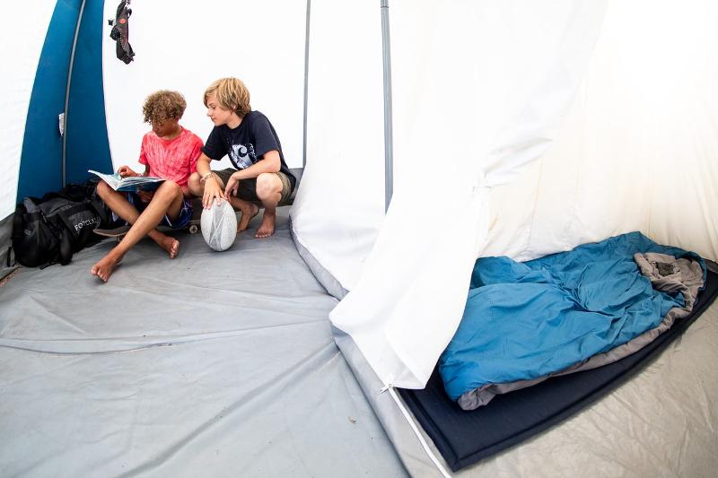 Jungs lesen etwas im Zelt auf der Surffreizeit