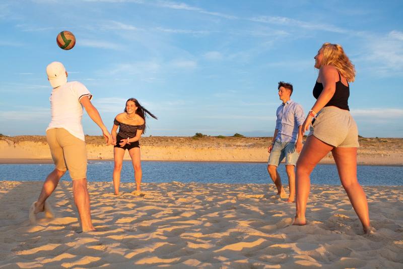 Jugendliche spielen Volleyball am Strand auf der Surffreizeit