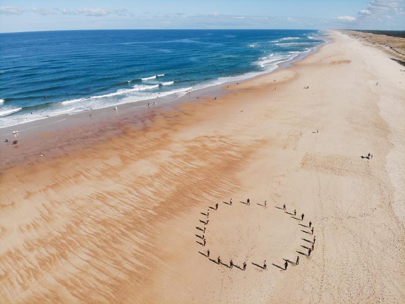 Teilnehmer bilden Kreis am Strand auf der Surffreizeit