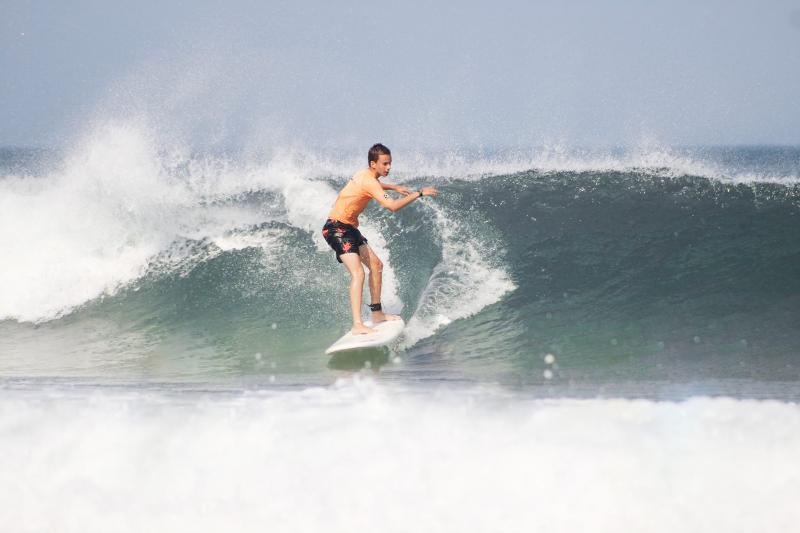 Junge fährt über Welle auf der Surffreizeit