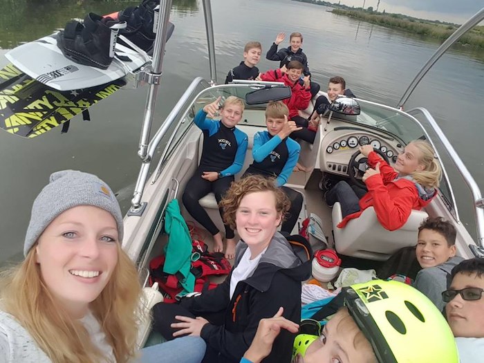 Teilnehmer lachen auf Boot im Kitesurf Camp