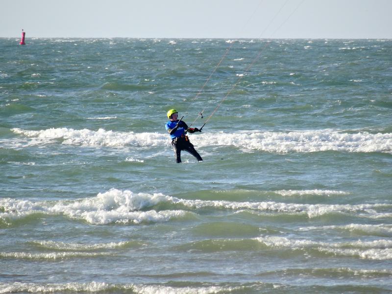 Im Feriencamp an der Nordsee kitesurft eine Junge auf den Wellen