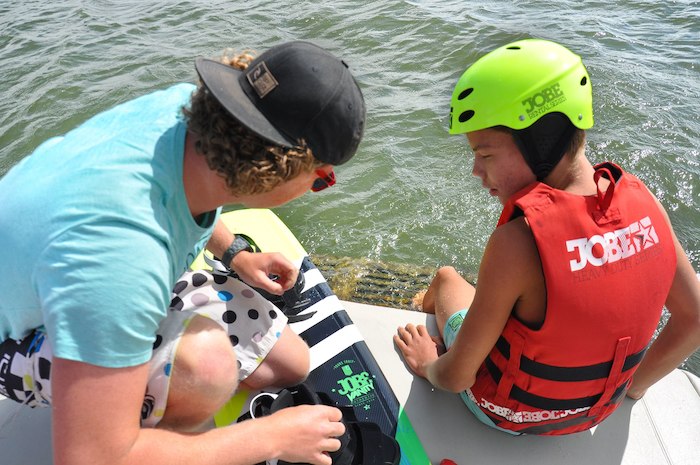 Ein Junge lernt Surfen im Kitesurf Camp