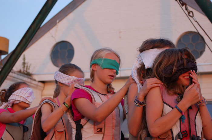 Kinder eines Herbstferiencamps spielen blinde Kuh