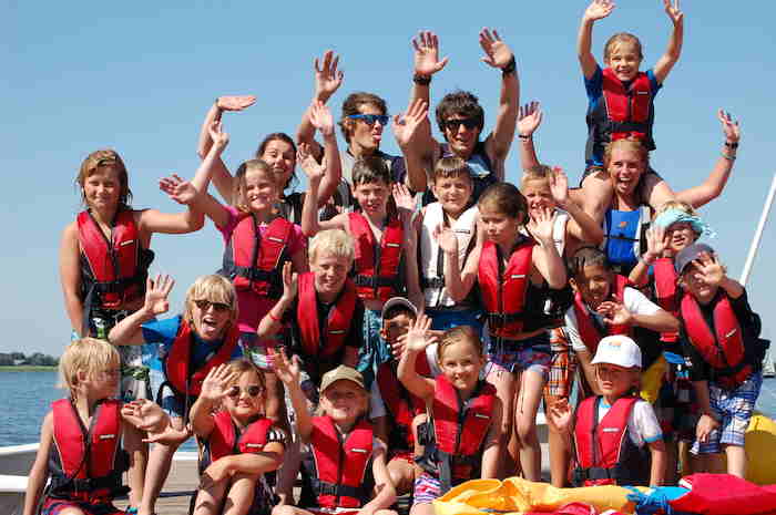 Die Kinder vom Segelcamp für Kinder winken in die Kamera auf dem Gruppenfoto