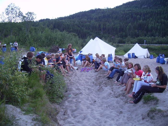 Jugendliche beim Abendessen im Sand bei der Kanu-Jugendreise Norwegen