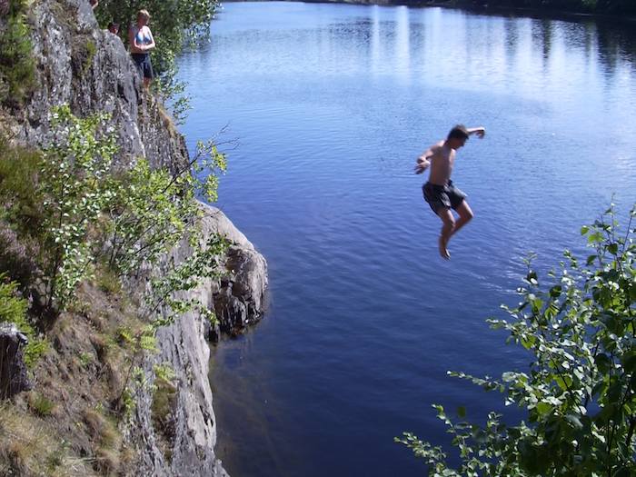 Ein Junge springt von einer Klippe bei der Jugendreise in Norwegen