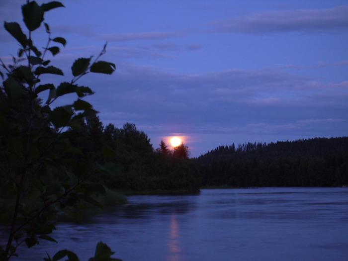 Bei der Jugendreise Norwegen ist ein Sonnenuntergang hinter Fluss und Wälder zu sehen