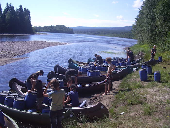 Kind räumen Kanus aus am Ufer auf der Jugendreise in Norwegen