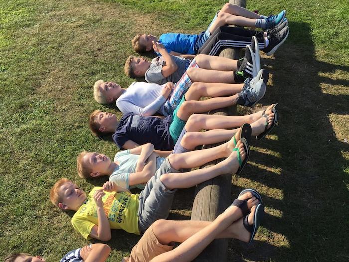 Kinder entspannen auf der Wiese im Sommercamp auf Sylt