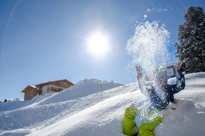 Junge auf Piste bei Sonnenschein im Wintercamp in Kössen