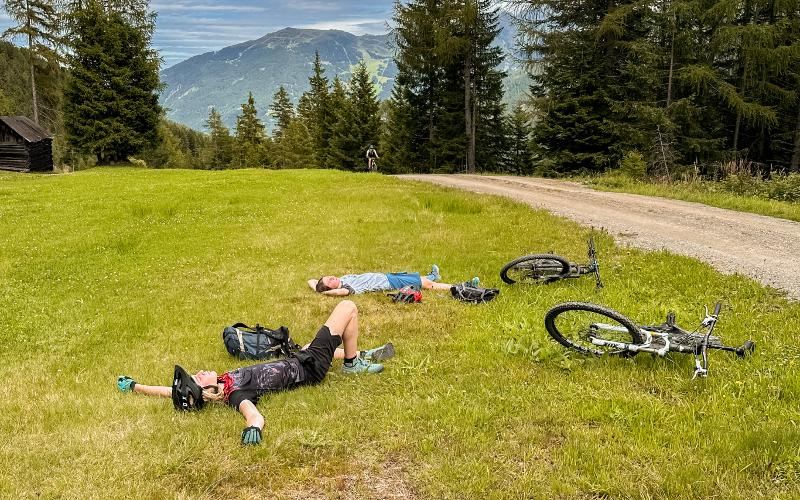 Zwei Jungen liegen im Mountainbike-Camp auf einer Wiese und schlafen