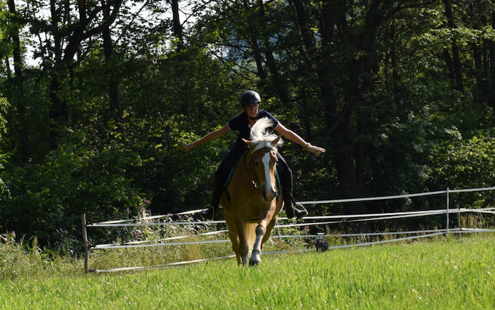 Mädchen übt Reiten auf einer Weise während den Reitferien in Tirol