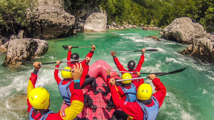 Teilnehmer eines Actioncamps Kärnten beim Wildwasserrafting in einem Fluss mit Stromschnellen