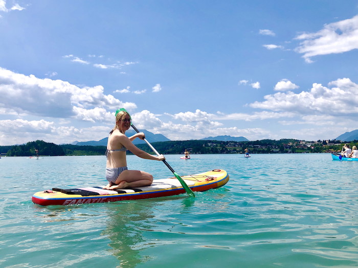 Mädchen am SUP-Board im See beim Feriencamp Kärnten