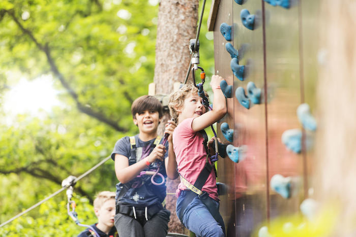 Die Kinder des Fußballcamps klettern an einer Kletterwand