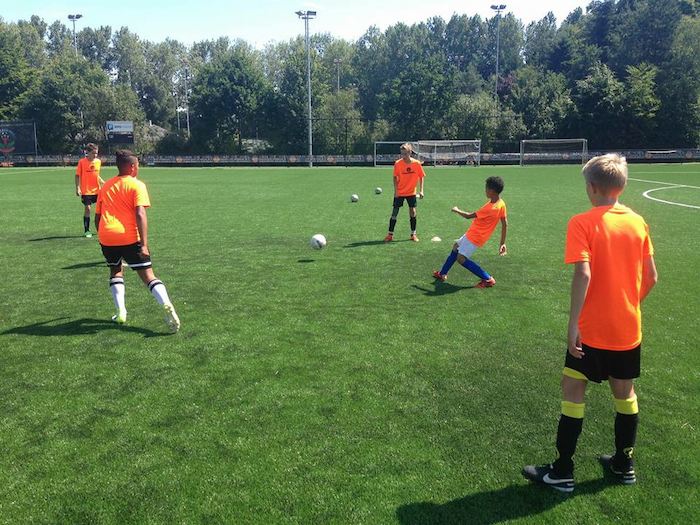 Sich gegenseitig den Ball zu spielen im Sport Feriencamp