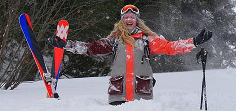 Mädchen bewirft sich mit Schnee im Skilager