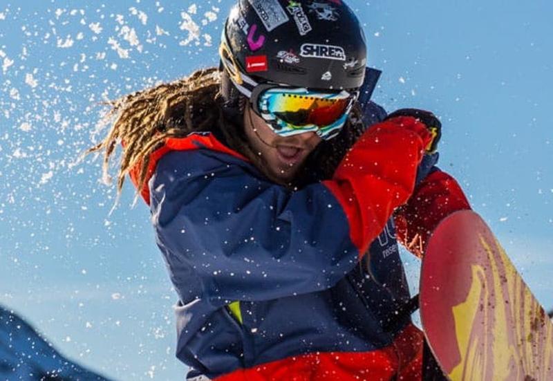 Snowboarder wird mit Schnee beworfen im Skilager