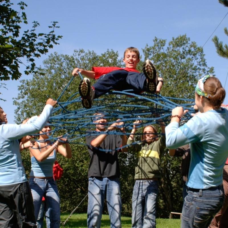 Im Sportcamp Vorarlberg steht eine Gruppe Jugendlicher im Kreis und spielt mit Seilten