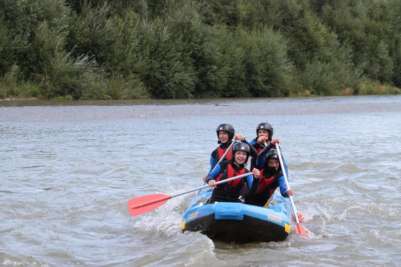 Teilnehmer des Englisch Camp Allgäu paddeln im Schlauchboot auf einem Fluss