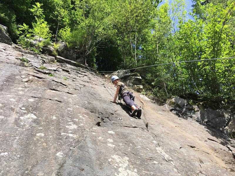 Mädchen klettert hoch auf den Felsen im Sprachcamp Englisch