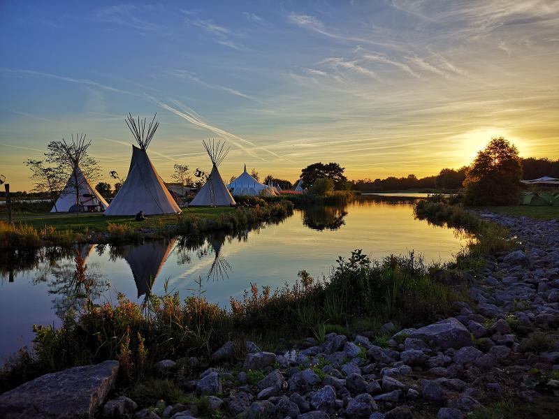 Eines der Feriencamps Deutschland in der Abenddämmerung sieht mit dem spiegelnden Wasser wunderschön aus.