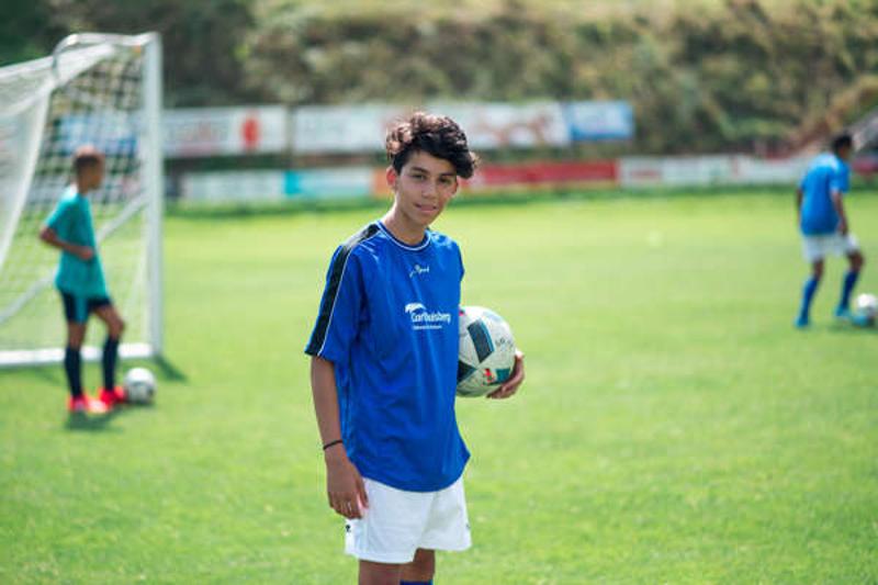 Junge hält Fussball im Fussballcamp am Bodensee