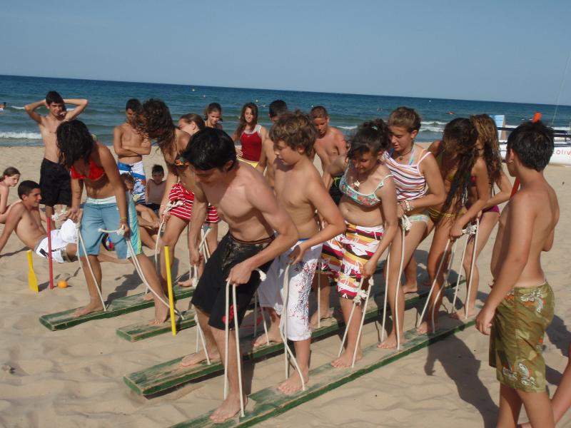 Jugendliche spielen lustige Spiel am Strand im International Summer Camp