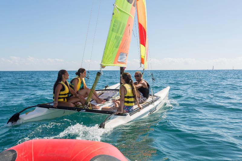 Jugendliche sitzen auf Boot im Feriencamp für Teenager