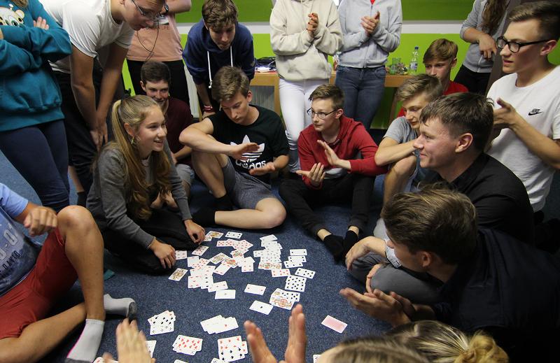 Kindergruppe spielt zusammen Karten im Ferienprogramm München