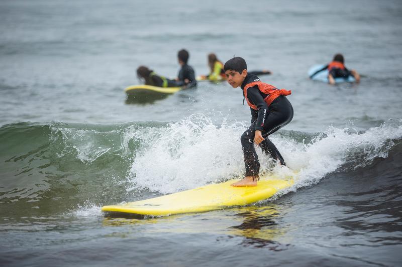 Kleiner Junge beim Surfen im Surf-Camp