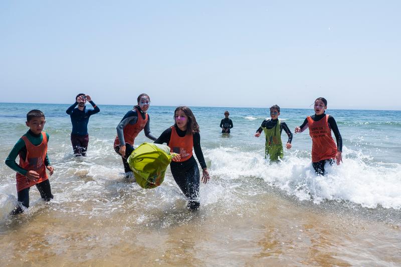 Kinder rennen aus dem Wasser im Surf-Camp in Portugal