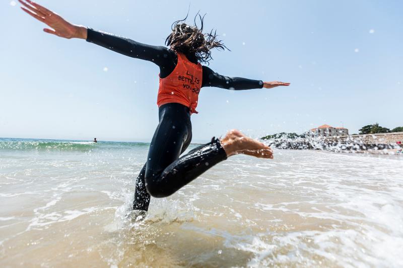 Mädchen rennt ins Wasser im Surf-Camp in Portugal
